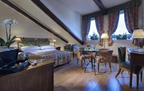 都灵贝斯特韦斯特皮耶蒙缇斯酒店的卧室配有一张床和一张桌子及椅子