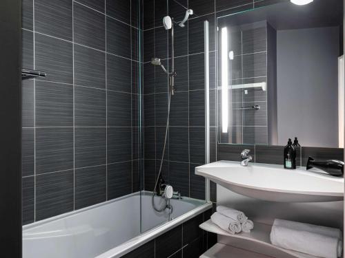 蒙鲁日巴黎蒙鲁爱达格公寓式酒店的一间带水槽、浴缸和卫生间的浴室