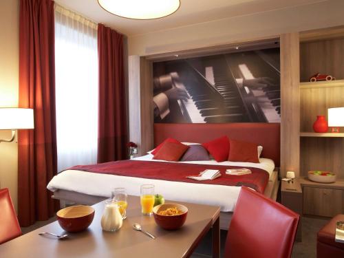 维也纳维也纳市阿德吉奥公寓式酒店的酒店客房带一张床、一张桌子和椅子