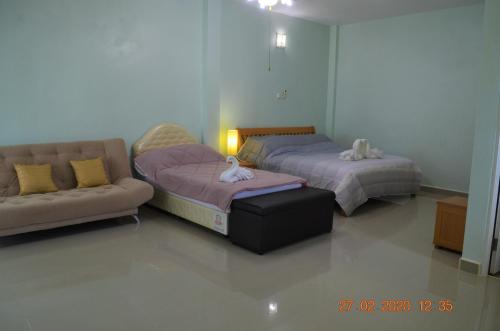 锡春Briya Beachfront Residence的客房内的两张床和一张沙发