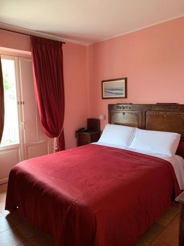 Castellinaldo蒙格里托酒店的一间卧室配有一张带红色床单的床和一扇窗户。