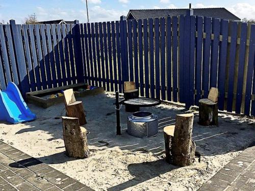 海默特8 person holiday home in Hemmet的一个带围栏、桌子和木柴的游乐场