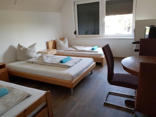 凯奇凯梅特Vándor Szálló的客房设有两张床、一把椅子和窗户。