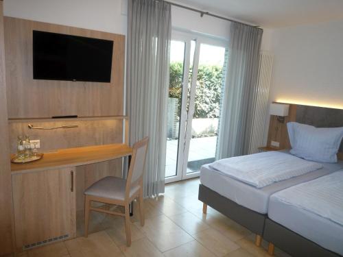 林根Hotel - Restaurant Veldscholten的一间卧室配有一张床和一张书桌及电视