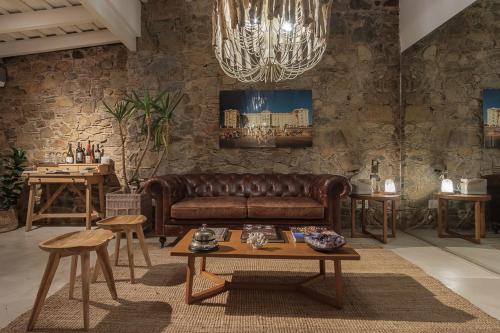 科洛尼亚-德尔萨克拉门托沙尔科酒店的客厅配有棕色皮沙发和桌子