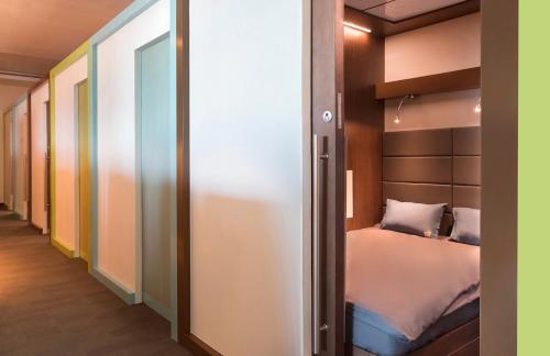 多哈sleep 'n fly Sleep Lounge, SOUTH Node - TRANSIT ONLY的一间带一张床和一个衣柜的小卧室