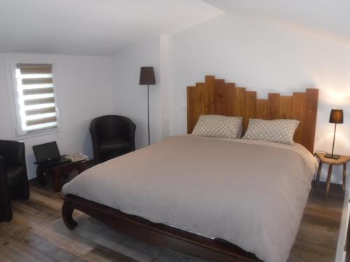 阿尔比La Maisonnette de l'échappée verte.的一间卧室配有一张大床和木制床头板