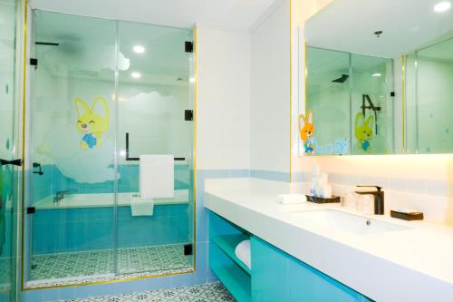 麦克坦Jpark Island Resort & Waterpark Cebu的浴室设有玻璃淋浴间和蓝色橱柜。