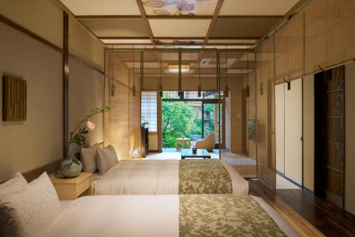 京都Nazuna Kyoto Nijo-jo的一间卧室设有两张床和大窗户