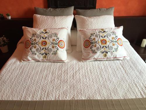圣费德勒·因特尔维Hotel Villa San Fedele的两个枕头和一张带白色床单的床