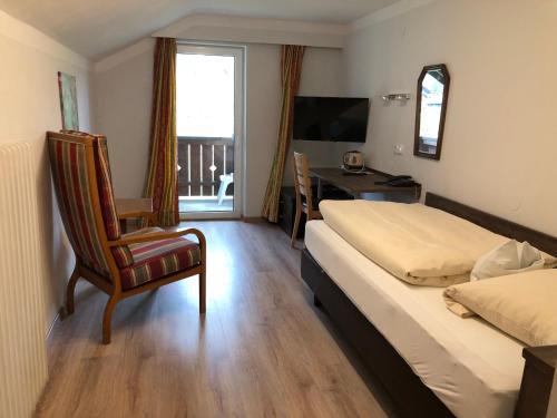 巴特维塞巴伐利亚酒店的一间卧室配有一张床、一把椅子和一张书桌