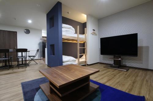 淡路Tiz wan 岩屋あわじ的客厅配有电视和双层床。