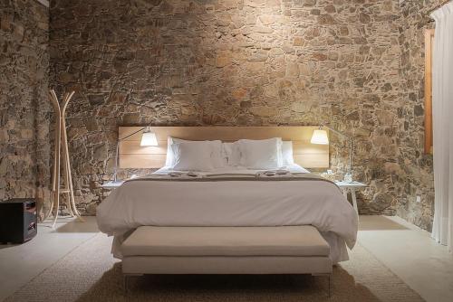 科洛尼亚-德尔萨克拉门托沙尔科酒店的一间卧室设有一张大床和石墙