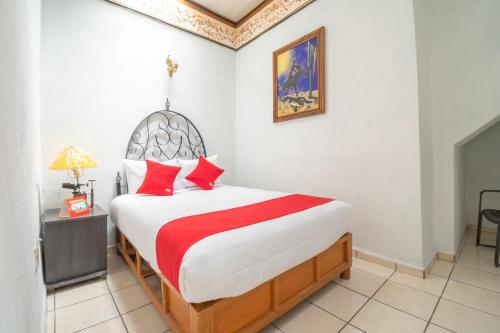 萨卡特卡斯OYO Hotel Meson de la Concepcion的一间卧室配有一张带红色枕头的大床