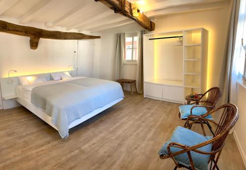 蒙绍Monschau-Auszeit: Historisch wohnen direkt am Bach的卧室配有白色的床和2把椅子