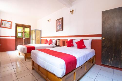 萨卡特卡斯OYO Hotel Meson de la Concepcion的一间卧室配有两张红色和白色床单