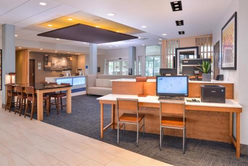 阿拉楚阿Holiday Inn Express & Suites Alachua - Gainesville Area, an IHG Hotel的办公室大堂,配有一张桌子和一台电脑