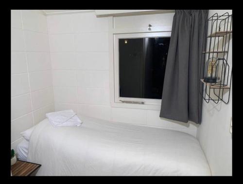 埃克斯鲁Bungalow 72的卧室配有白色的床和窗户。
