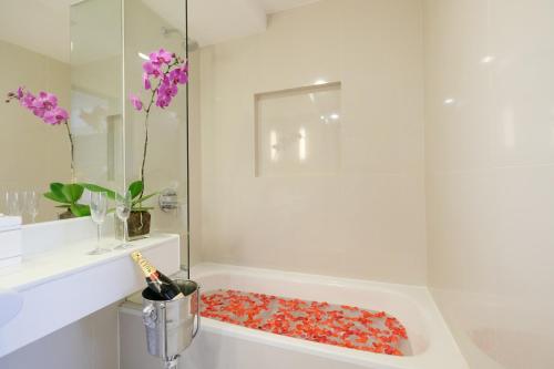 宿务Quest Hotel & Conference Center Cebu的浴室设有淋浴和红色球浴缸。