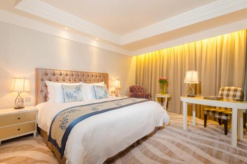 上海上海古北湾大酒店的一间卧室配有一张大床和一张书桌