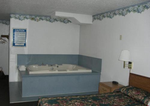 罗斯维尔Norwood Inn and Suites - Minneapolis-St Paul Roseville的卧室内带浴缸的房间