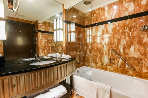 马尼拉Diamond Hotel Philippines的带浴缸、水槽和浴缸的浴室