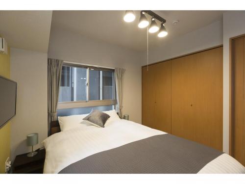长崎Coruscant Hotel Nagasakieki的一间卧室设有一张大床和一个窗户。
