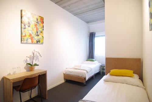 阿姆斯特丹Stunning apartments close to Amstel river的客房设有两张床、一张桌子和一张桌子。