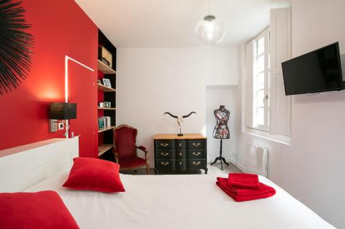 佩里格Corps et graphi(qu)es的一间红色的卧室,配有白色的床和红色的墙壁