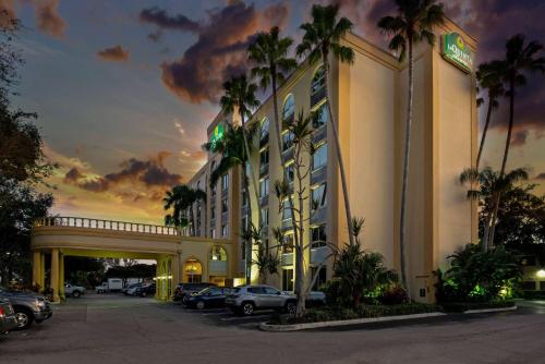 西棕榈滩西棕榈滩机场拉昆塔酒店 的停车场内有车辆的旅馆