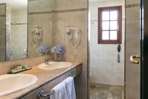 下布雷尼亚帕拉多尔帕尔马酒店的一间带两个盥洗盆和淋浴的浴室