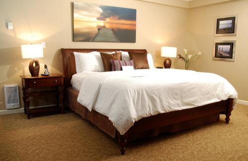 温哥华斯坦利罗斯伦套房酒店的一间卧室配有一张大床和两盏灯。