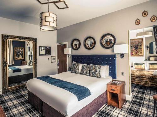 诺丁汉诺丁汉市中心美居酒店的一间卧室配有一张大床和镜子