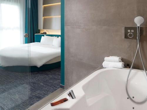 尼韦勒尼韦尔宜必思尚品酒店的带浴缸和床的浴室