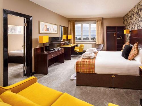 艾尔艾尔美居酒店的酒店客房设有一张大床和一张书桌。