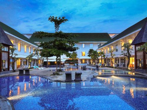 Banjarbaru班甲玛辛诺富特机场的夜间带大型游泳池的酒店庭院