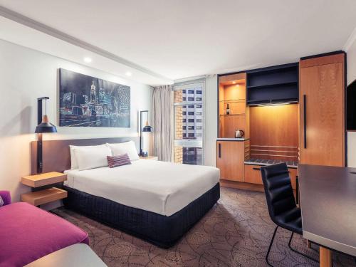 布里斯班布里斯班乔治国王广场美居酒店的配有一张床和一张书桌的酒店客房