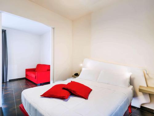 巴勒莫Ibis Styles Palermo President的客房内的白色床和红色椅子
