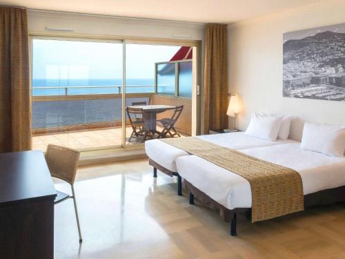 尼斯尼斯英国大道阿德吉奥公寓式酒店的酒店客房设有一张大床和一个阳台。