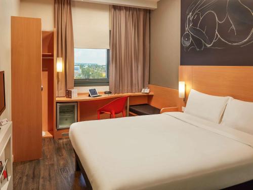 安卡拉宜必思安卡拉机场酒店的酒店客房设有一张大床和一张书桌。