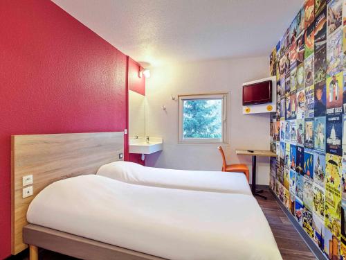 圣但尼hotelF1 Paris Saint Denis Stade的酒店客房设有三张床和电视。