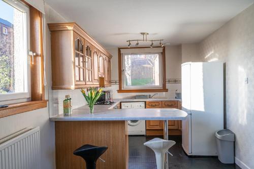 邓迪Broughty Ferry Apartment的厨房配有白色冰箱和木制橱柜。