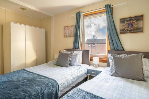 邓迪Broughty Ferry Apartment的一间卧室设有两张床和窗户。