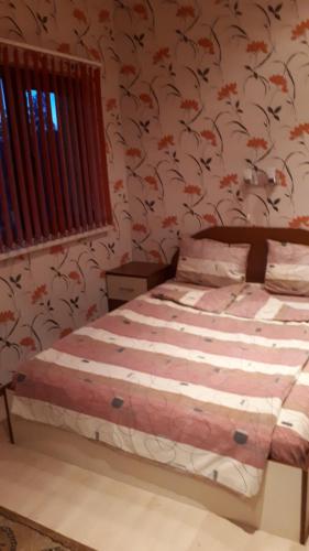 索非亚Guest House Blisten的一间卧室配有一张带花卉壁纸的床
