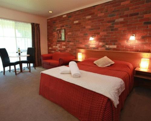 曼斯菲尔德曼斯菲尔德山谷汽车旅馆的酒店客房,设有床铺和砖墙