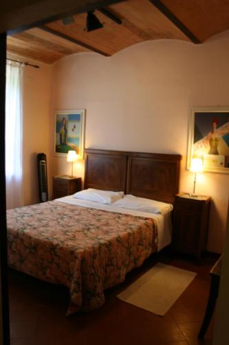 基安蒂盖奥勒Podere Il Trebbio, porzione di villa的一间卧室配有一张床和两盏灯。