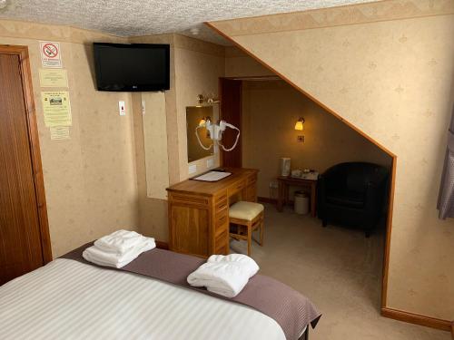 因弗内斯林登宾馆的酒店客房配有一张床、一张书桌和一台电视。