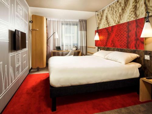 剑桥宜必思剑桥中央车站酒店的酒店客房,配有床铺和红地毯