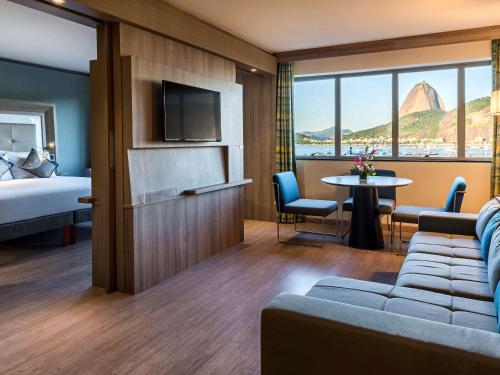 里约热内卢诺富特RJ普莱雅波塔佛歌酒店的酒店客房设有沙发、床和桌子。
