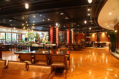 大连大连金石滩鲁能温泉假日酒店的餐厅铺有木地板,配有桌椅
